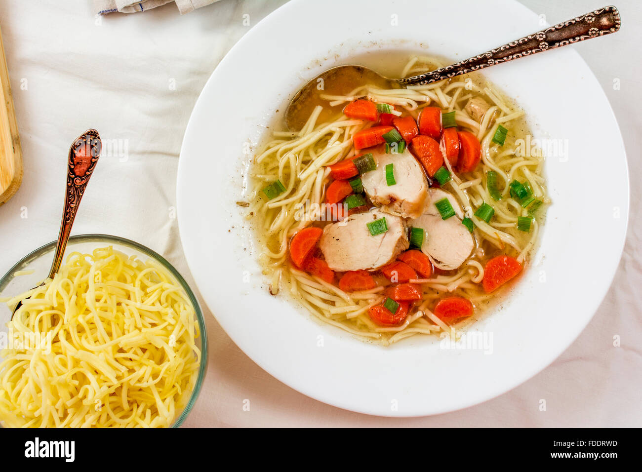 Traditionelle Hühnersuppe mit Fleisch und Karotten und Nudeln auf weißen Tisch Stockfoto