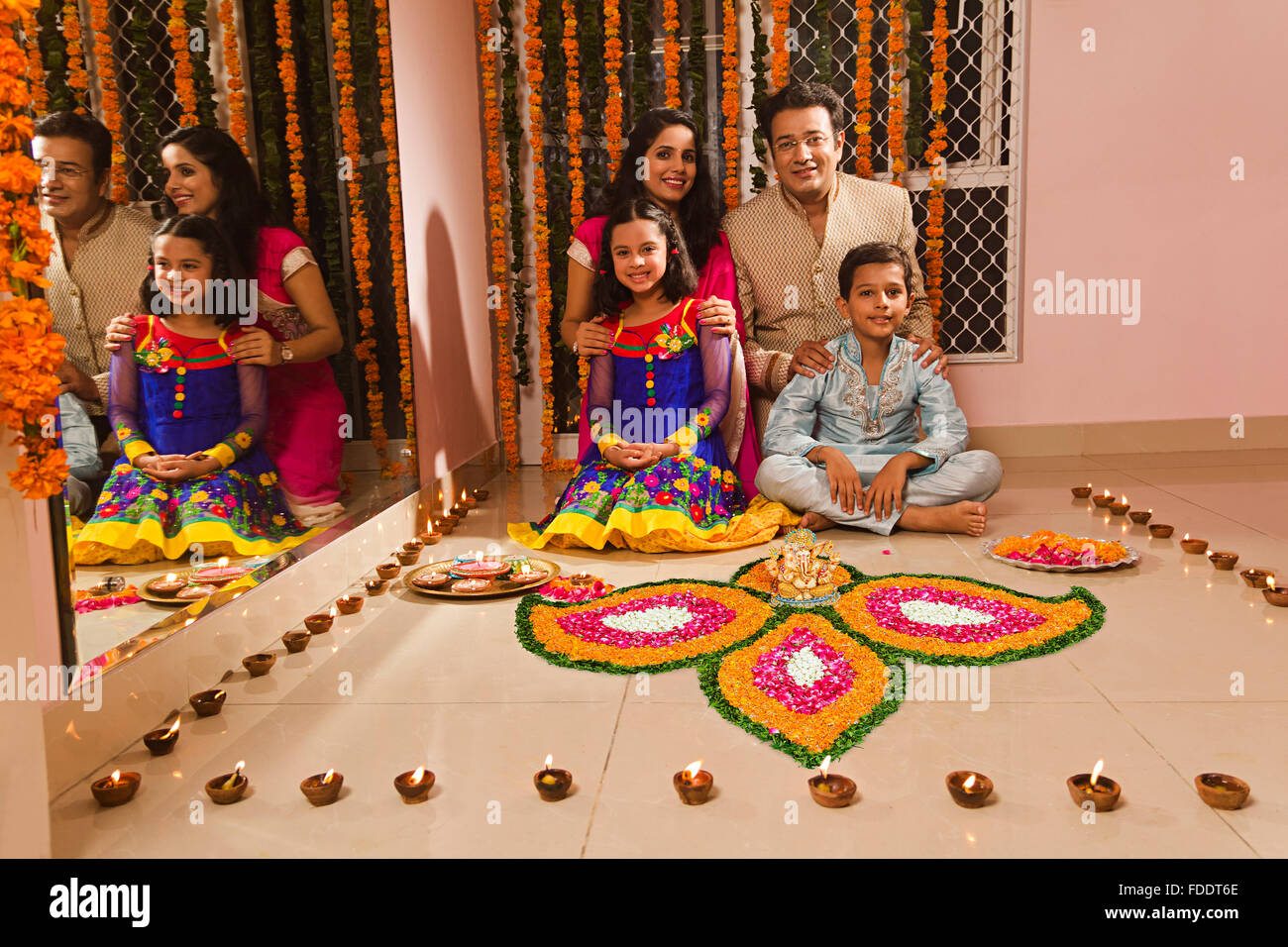 4 Personen Eltern und Kinder Diwali Festivals Home Rangoli Dekoration Stockfoto