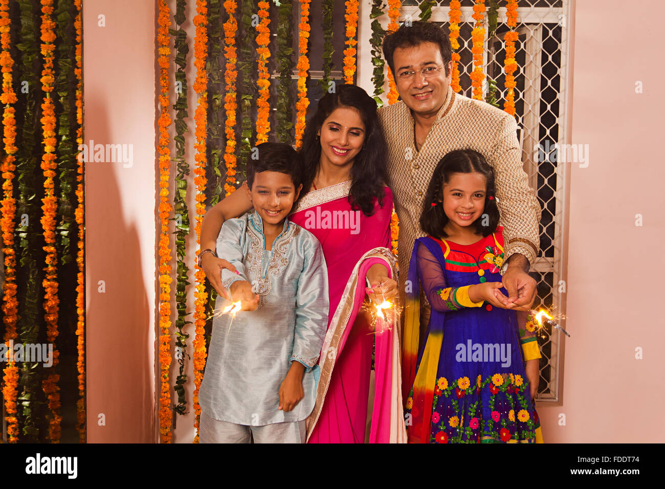 4 Personen Eltern und Kinder Diwali Feste feiern Holding Feuerwerkskörper Stockfoto
