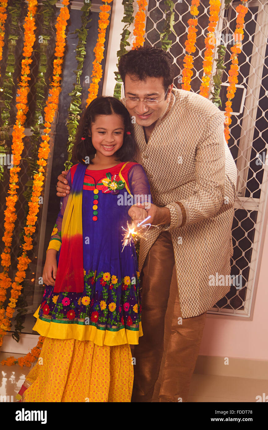 2 Personen Vater und Kind Tochter Diwali Feste feiern Holding Feuerwerkskörper Stockfoto