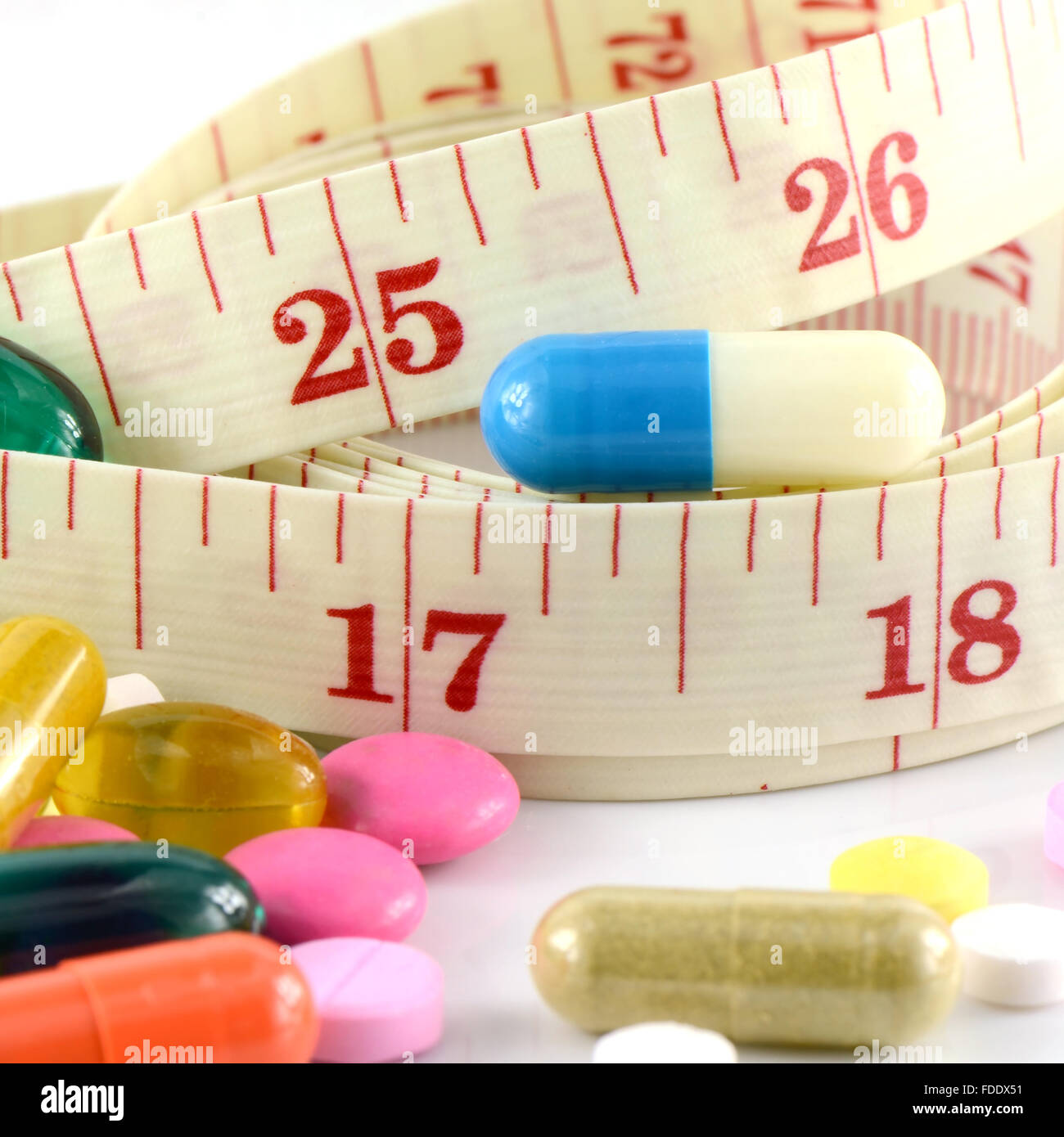 Medizin und Maßband auf weißem Hintergrund in Taille und Gewicht Steuerungskonzept. Stockfoto