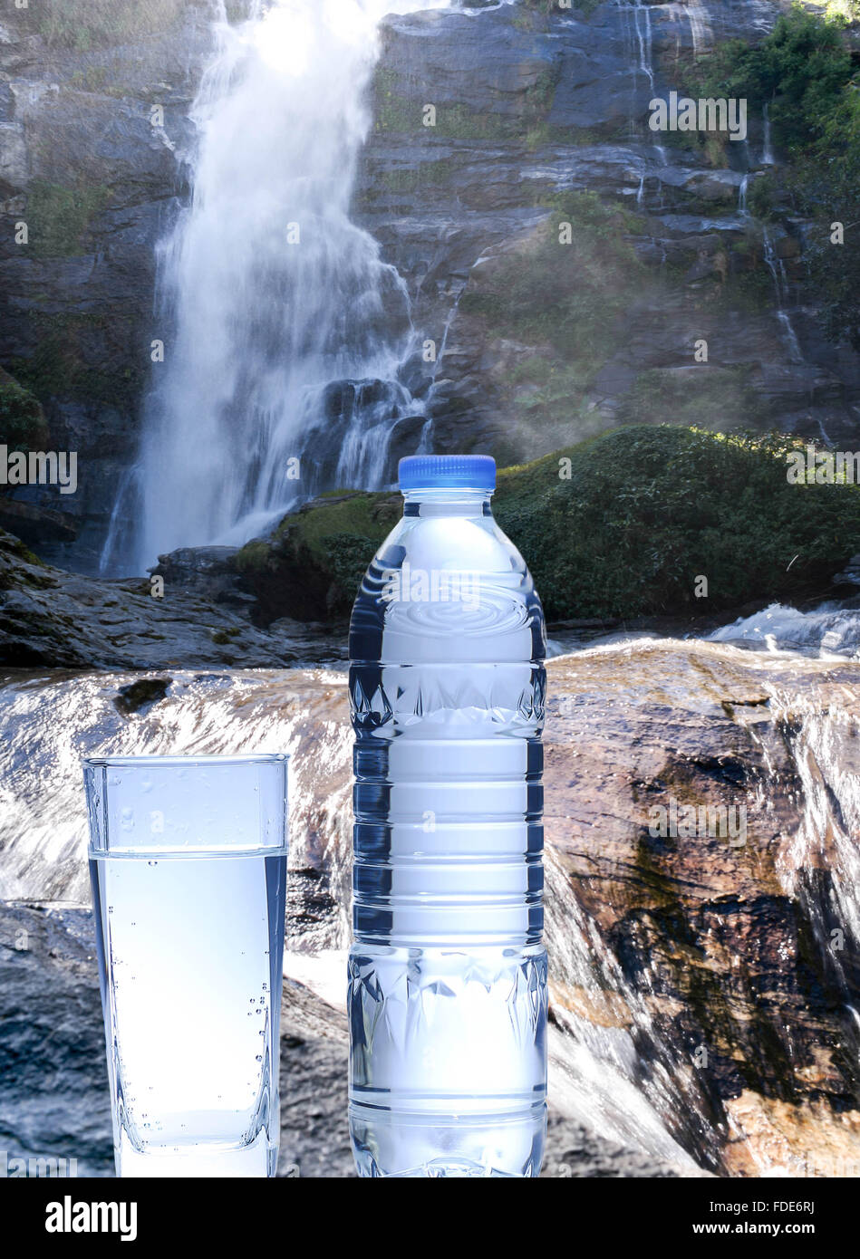 Flasche frisches Mineralwasser mit Wasserfällen im Hintergrund Stockfoto