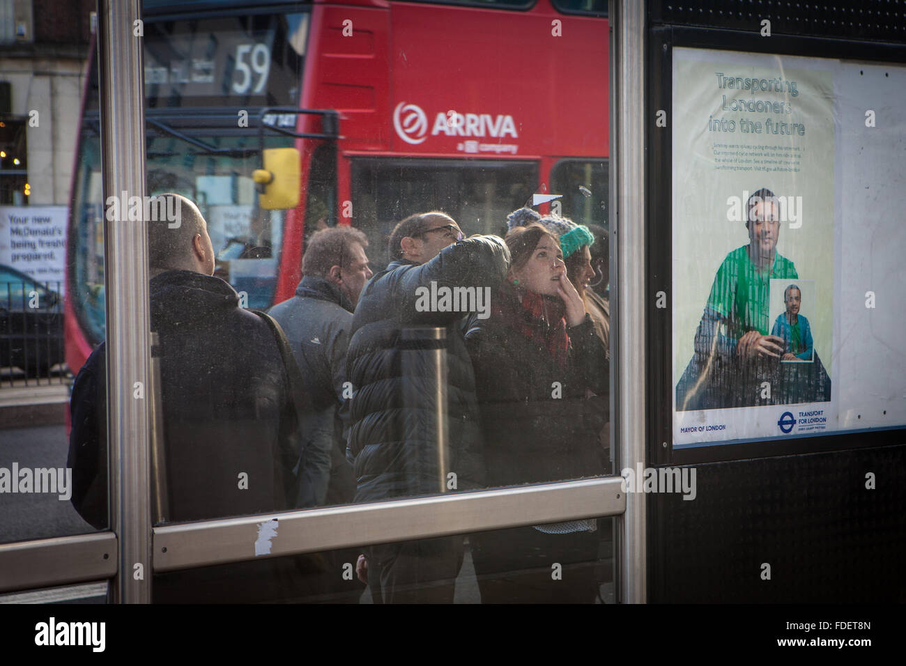 Paar Überprüfung Busfahrplan an London Bus Stop Stockfoto