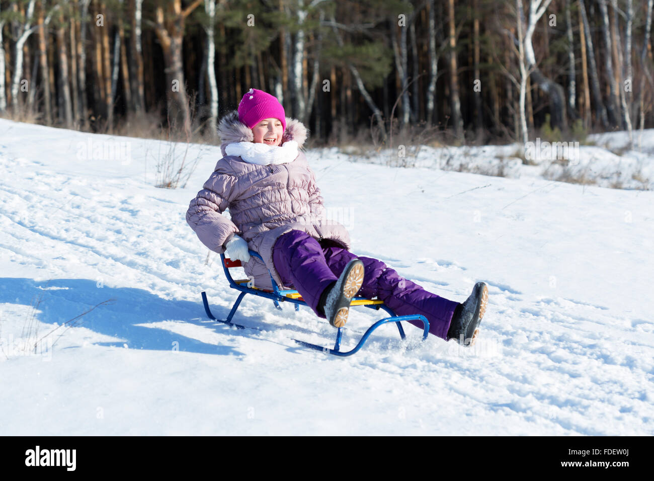 Mädchen genießen Schlittenfahrt in schönen verschneiten Winter park Stockfoto