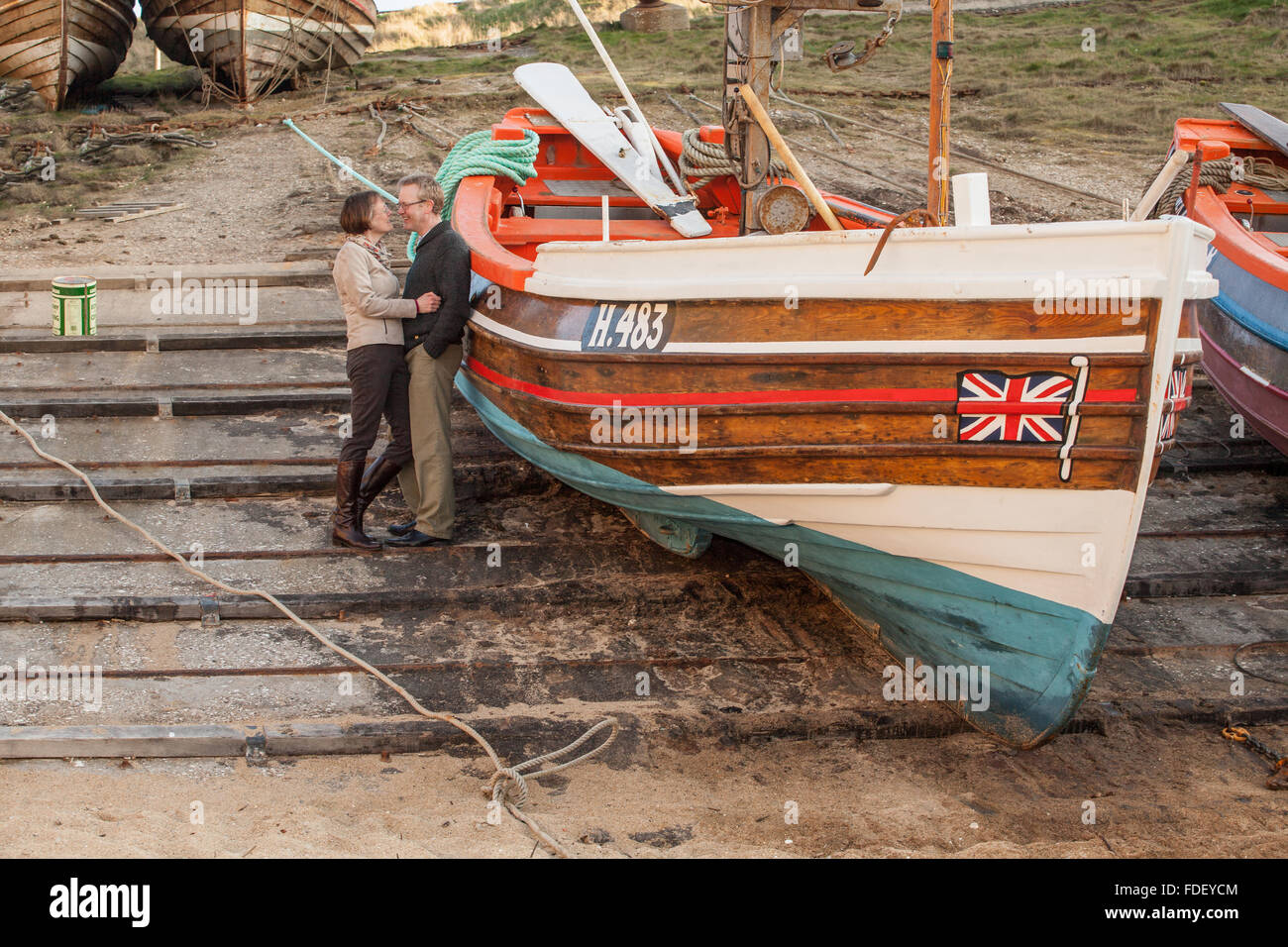 Paar in intimen Gespräch über Slipanlage mit dem Boot bei Flamborough Head, Yorkshire, Großbritannien. Stockfoto
