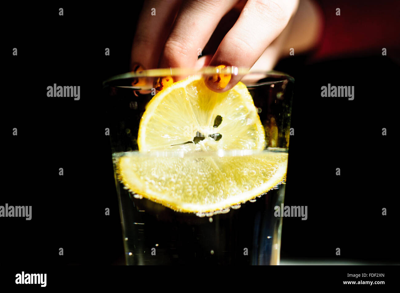 Statt eine Scheibe der Zitrone in ein Glas Wasser Stockfoto