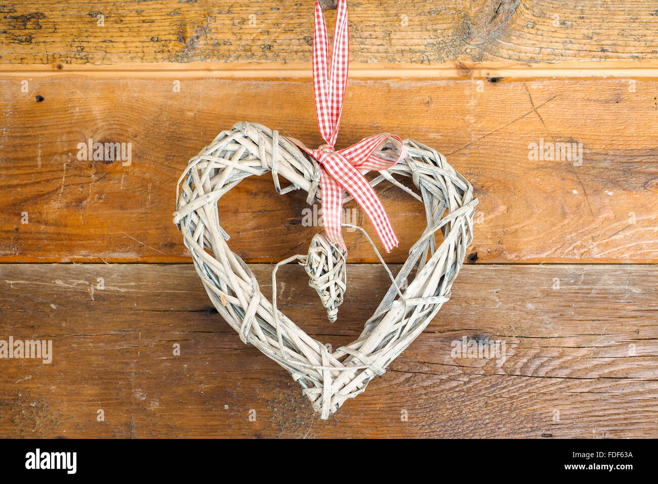 Hausgemachte Herz gebaut mit Stroh, gehängt, hölzerne Wand, Saint Valentinstag zu feiern. Stockfoto