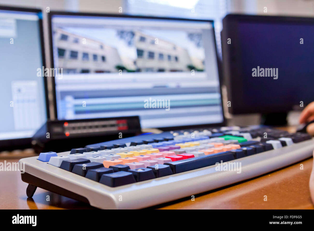 Editor schneiden TV-Footage über Tastatur mit Bildschirmen Stockfoto