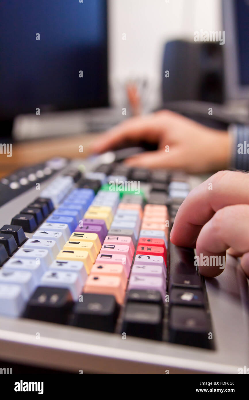 Editor schneiden TV-Footage über Tastatur mit Bildschirmen Stockfoto
