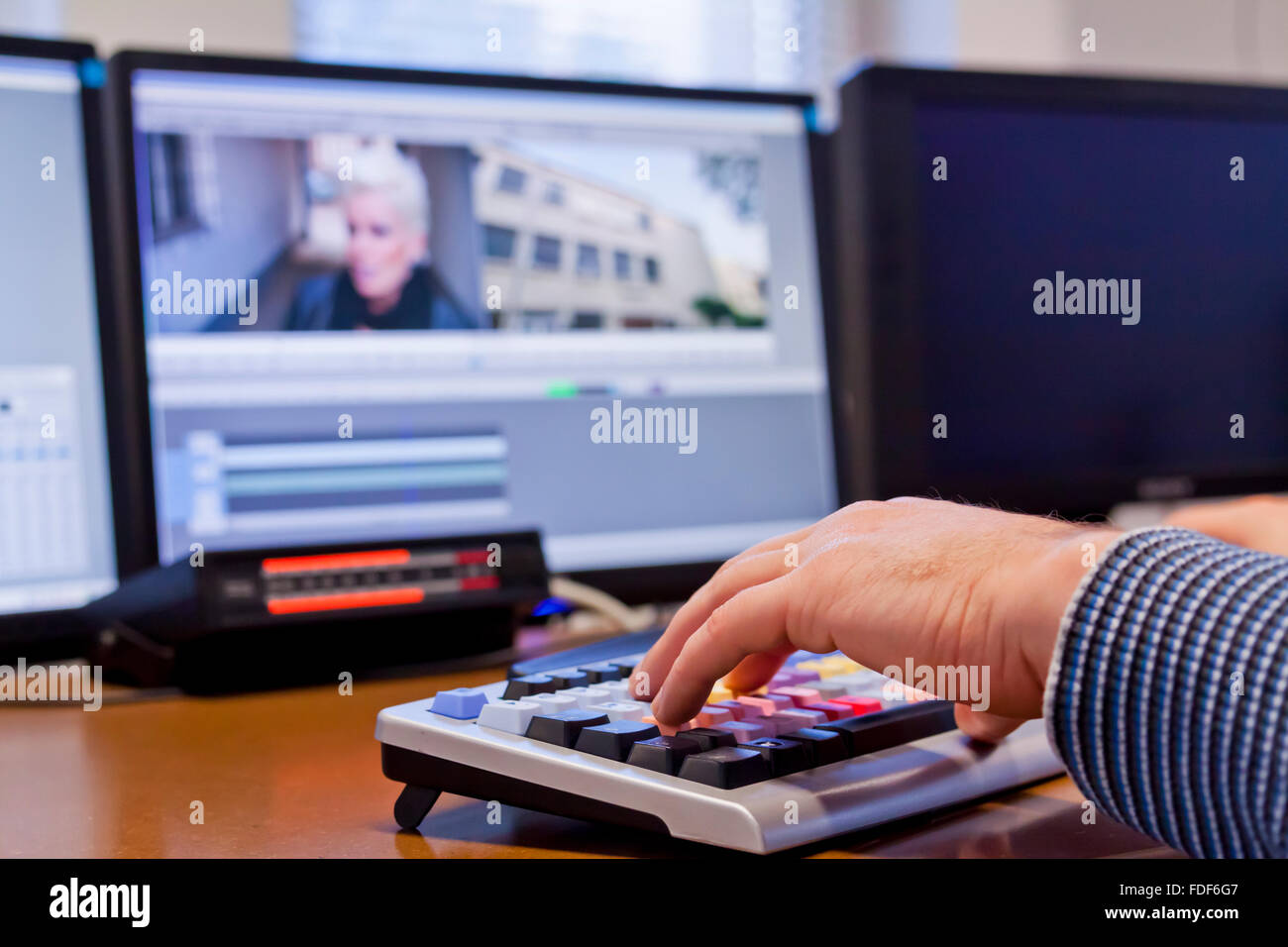 Editor schneiden TV-Footage über Tastatur mit Bildschirmen Stockfoto