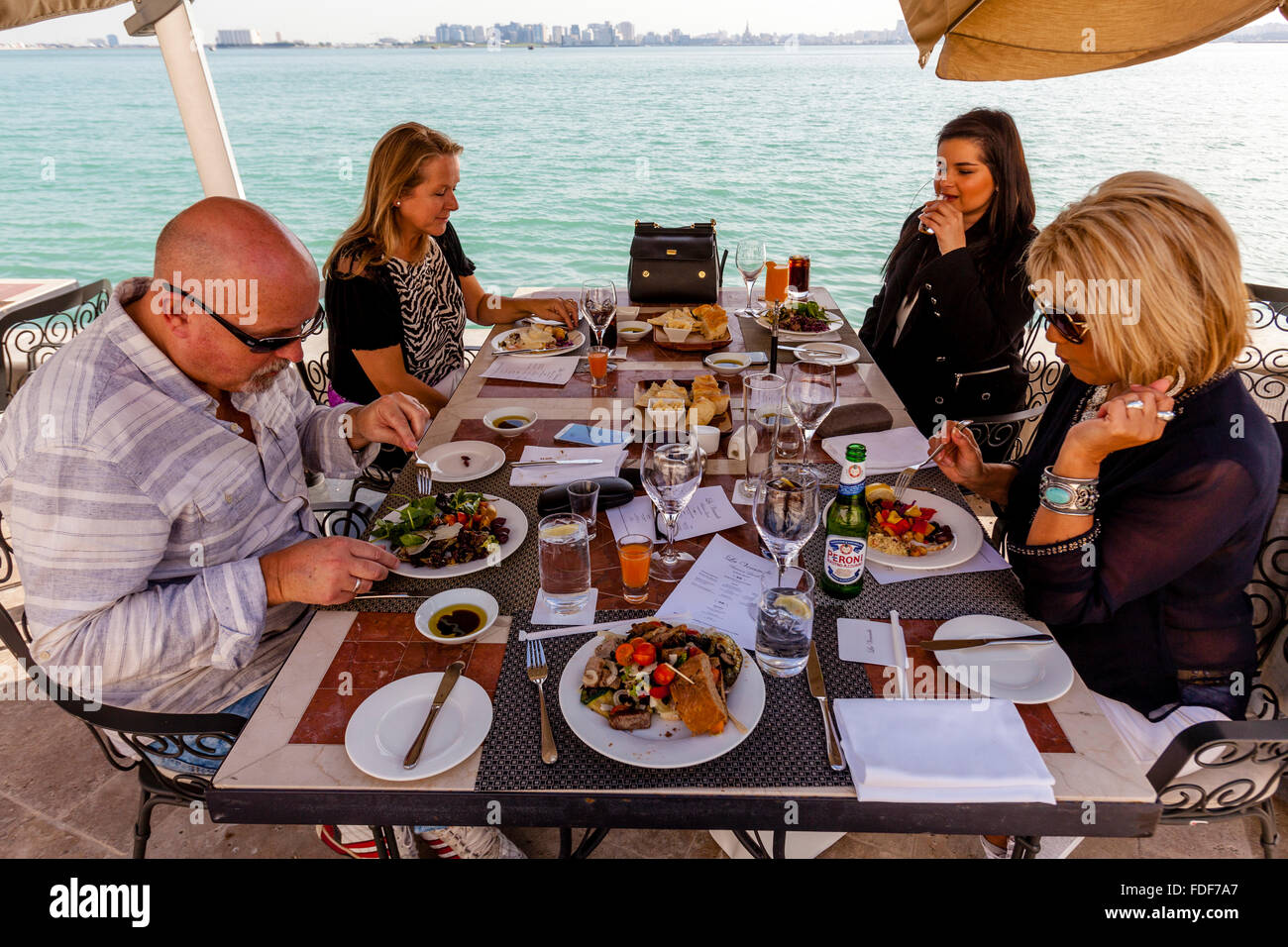 Ein Ex-Pat-Familie beim Mittagessen in einem Restaurant am Wasser, Doha, Katar Stockfoto