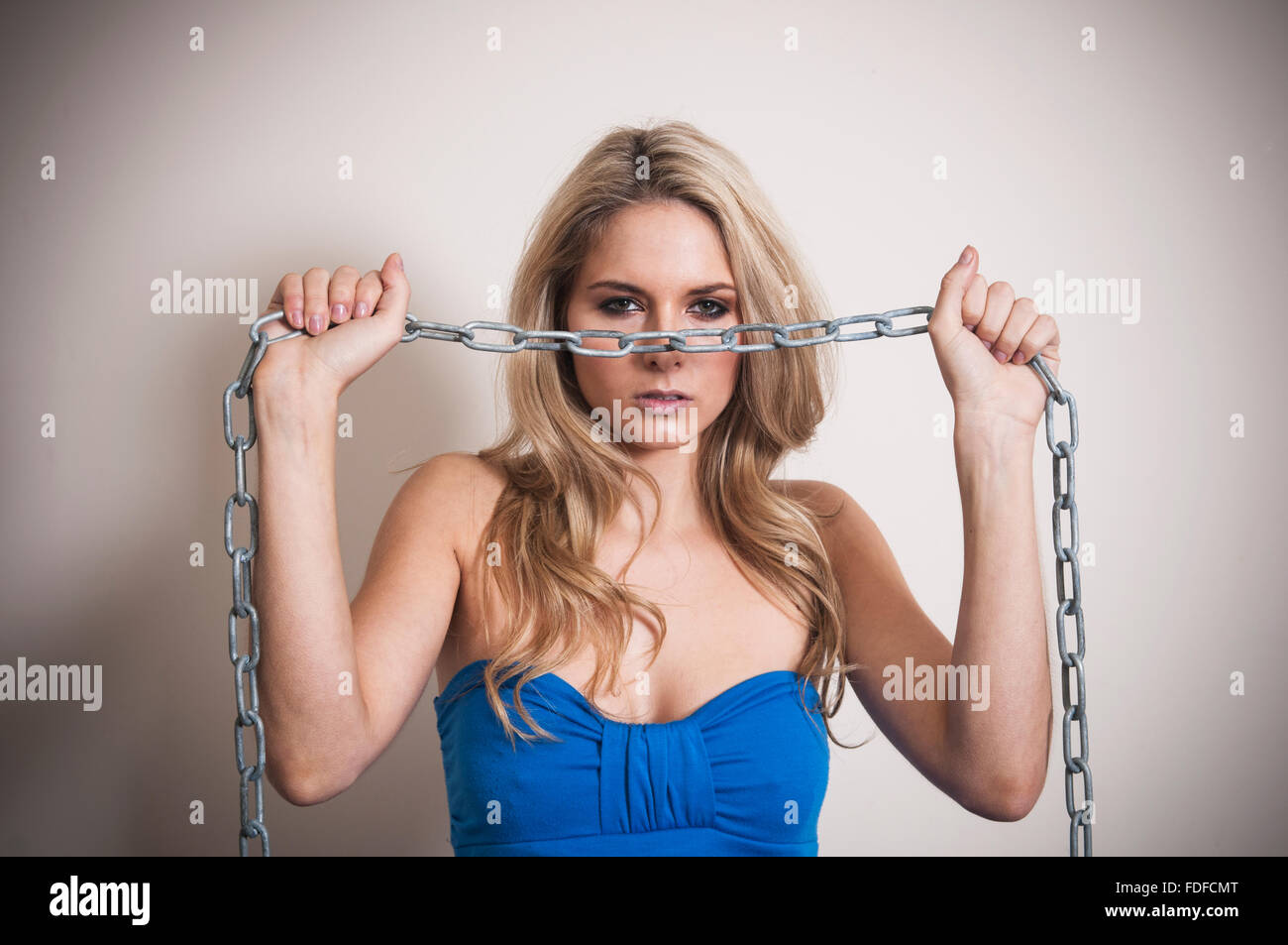 Böse Frau, die mit einer Metallkette Stockfoto