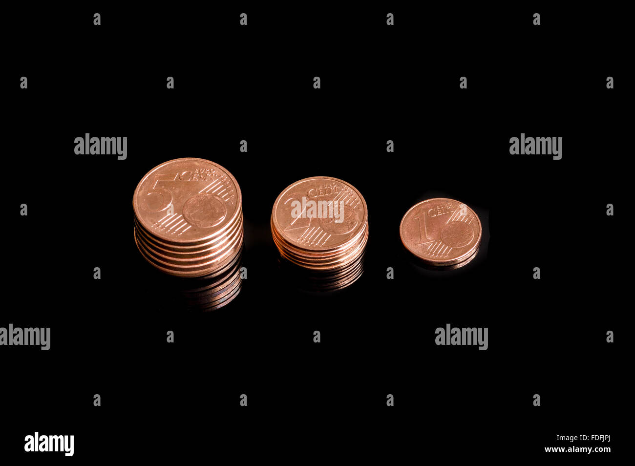 Nahaufnahme von drei schrumpfenden Stapel von Euro-Cent-Münzen auf schwarzem Hintergrund isoliert Stockfoto