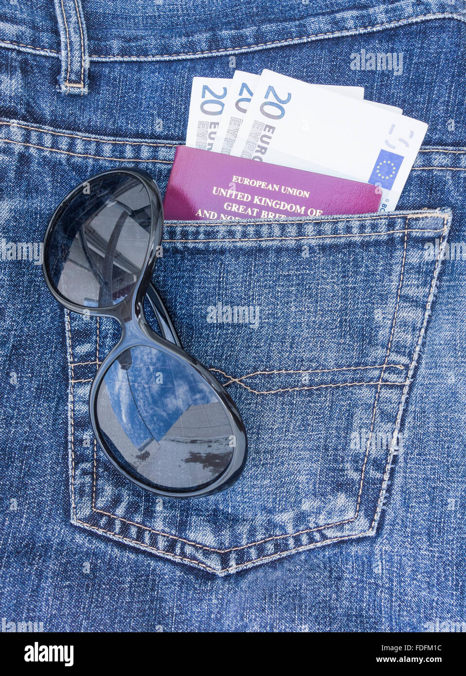 Pass, Euro-Banknoten und Sonnenbrillen in der Gesäßtasche der Jeans. Reisekonzept Stockfoto