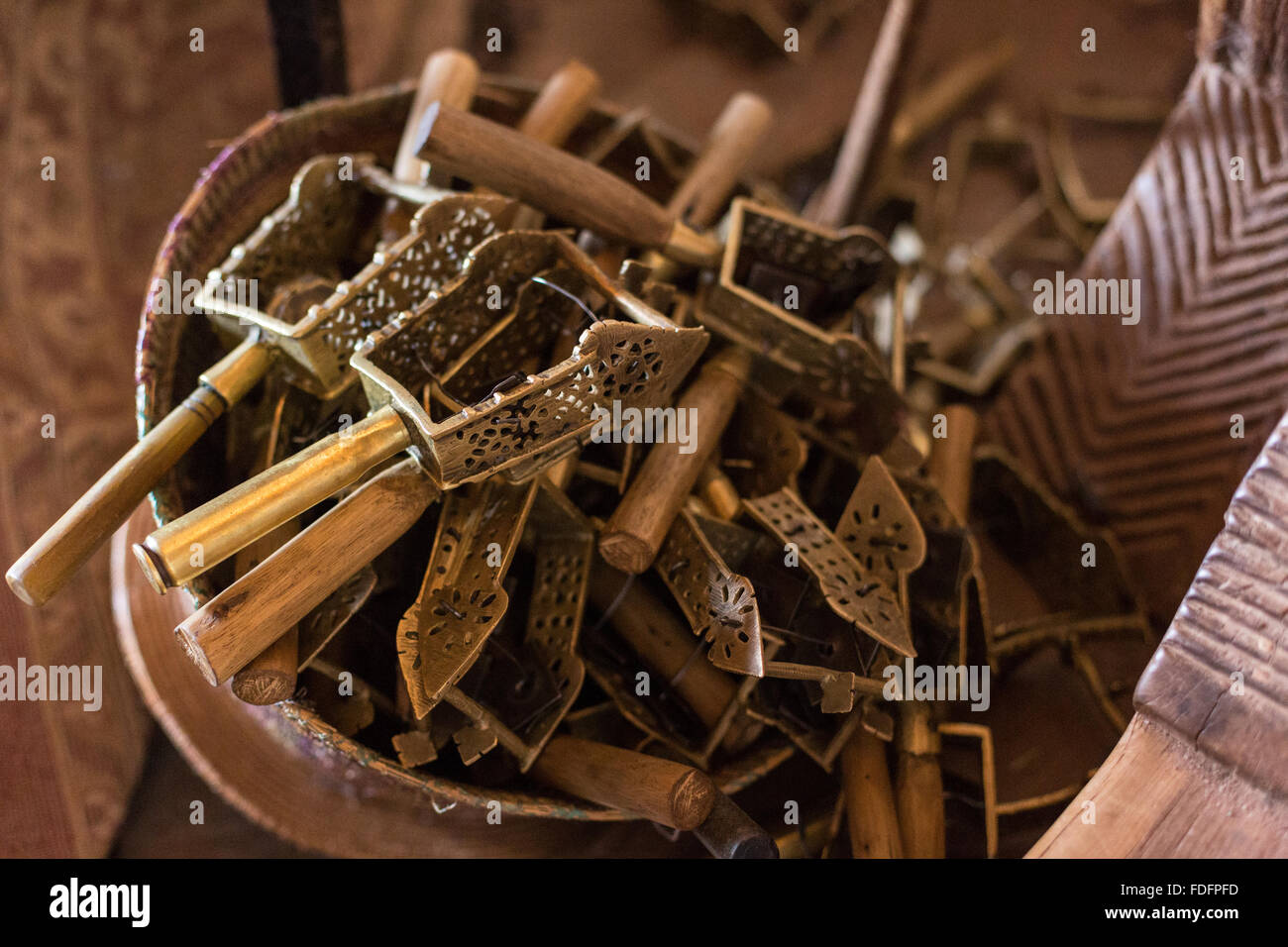 Ein geflochtener Korb hält eine Anzahl von Sistren in Gottesdiensten, im Inneren eine Felsenkirche in Wukro, Äthiopien verwendet. Der Griff eines von ihnen ist eine große Kugel Messinggehäuse. Stockfoto