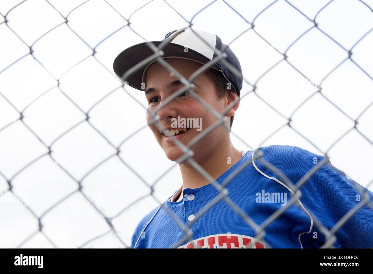 Glücklich kleine Liga Baseball-Spieler 12 Jahre in Uniform hinter Rücklaufsperre. St Paul Minnesota MN USA Stockfoto