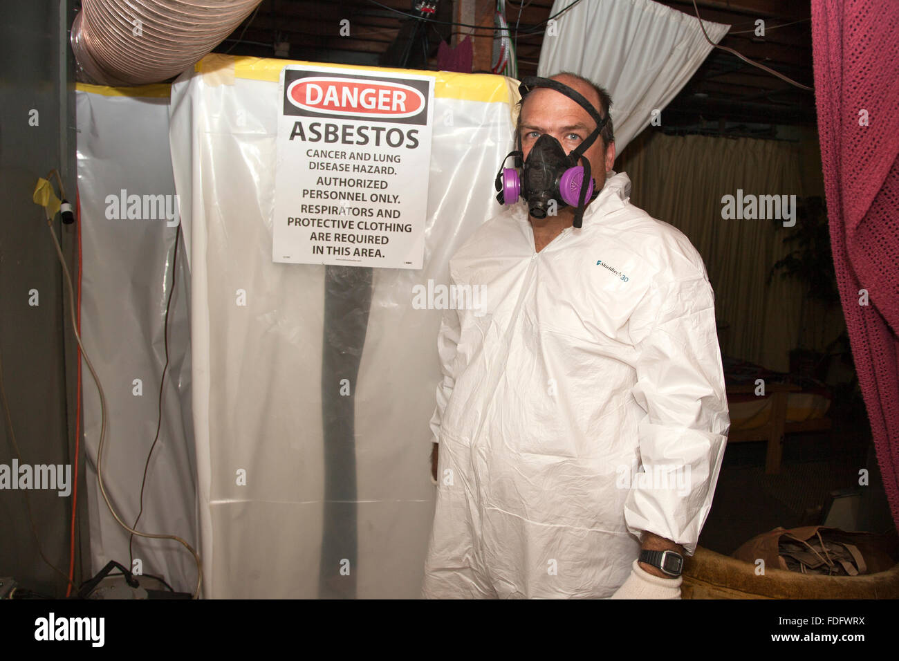 Arbeiter in Schutzmaske und Ganzkörperanzug bereit, einen alten Ofen Asbest Isolierung entfernen. St Paul Minnesota MN USA Stockfoto