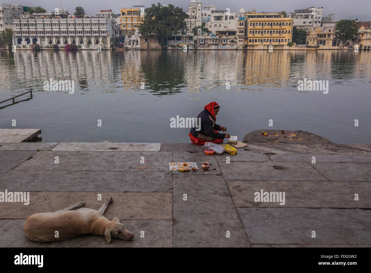 Eine Hindu-Frau macht einer Puja ein Gebet an den Ufern des Lake Pichola, Udaipur, Indien anbieten. Stockfoto