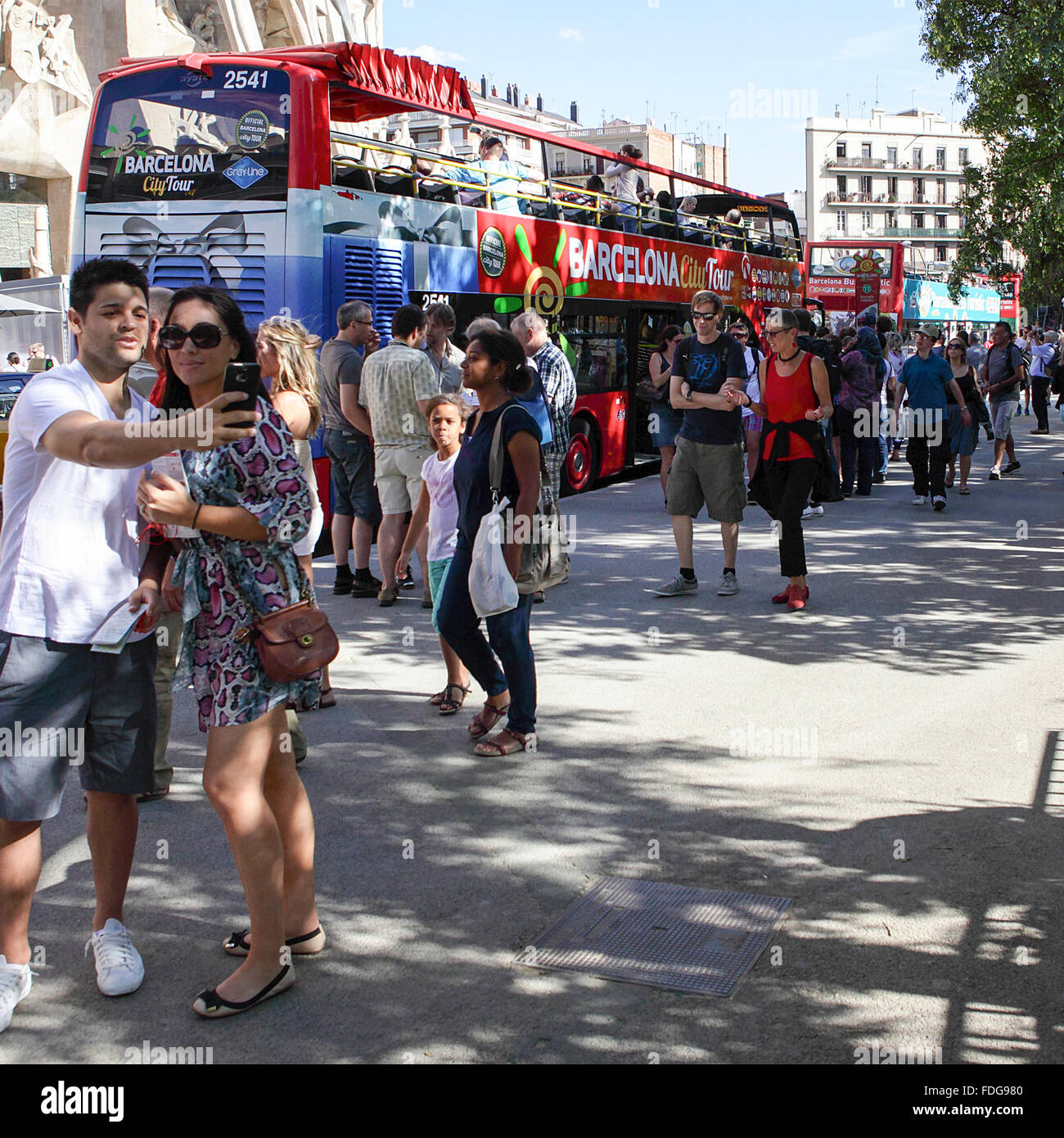 Unglaublich detaillierte Mauerwerk, Touristen Schlange und Reisebusse machen der Gegend rund um De Sagrada Familia ein reges Treiben. Stockfoto