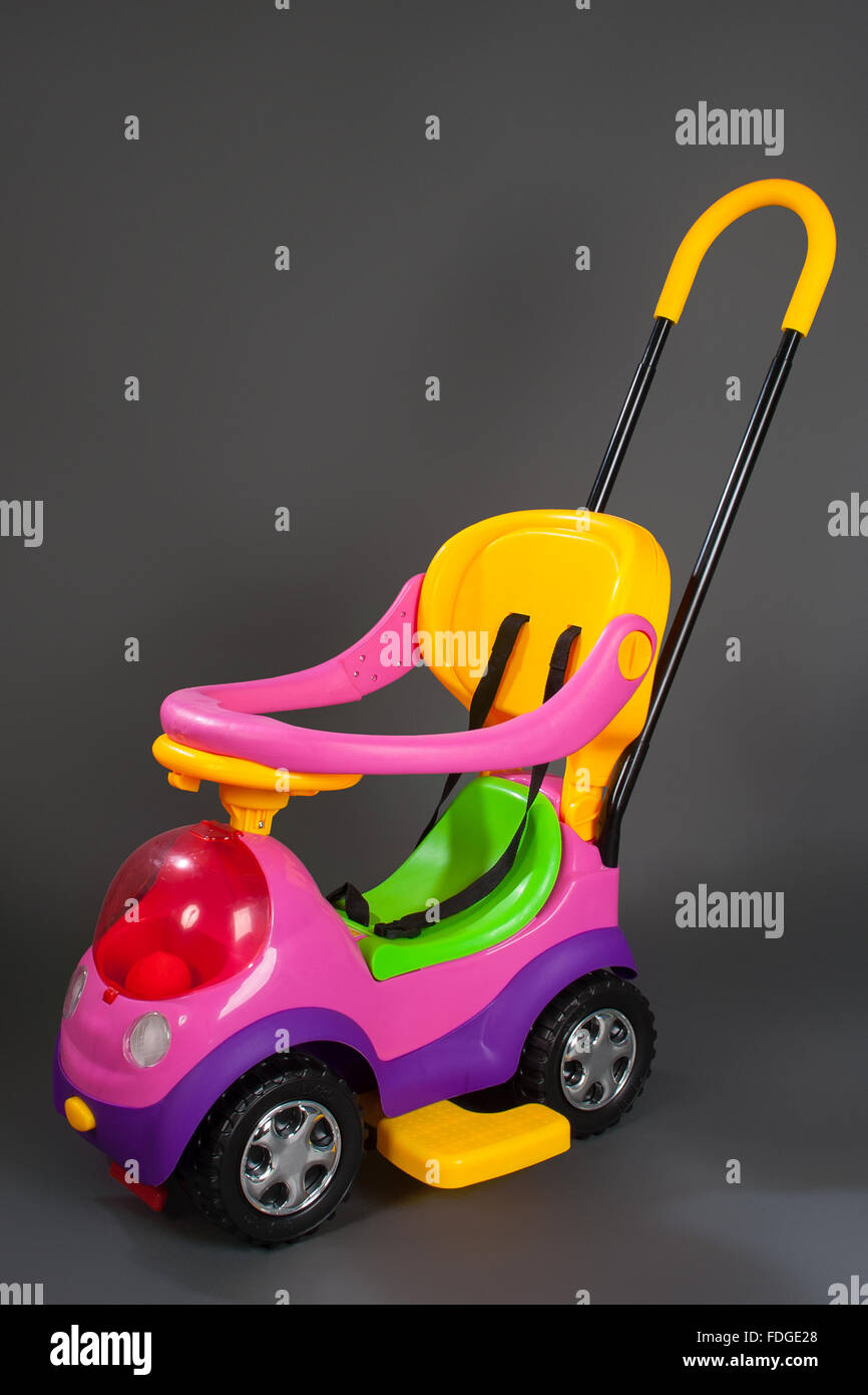 Schöne Baby moderne Kinderwagen wie ein Auto auf grauem Hintergrund isoliert Stockfoto