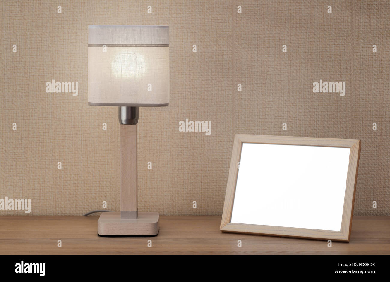 Leere Bilderrahmen und Lampe auf Holztisch Stockfoto