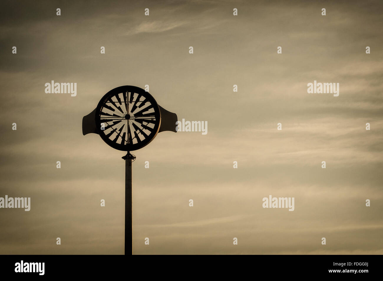 Künstlerische Anemometer gegen den warmen Himmel von Sonnenaufgang an einem bewölkten Tag Stockfoto