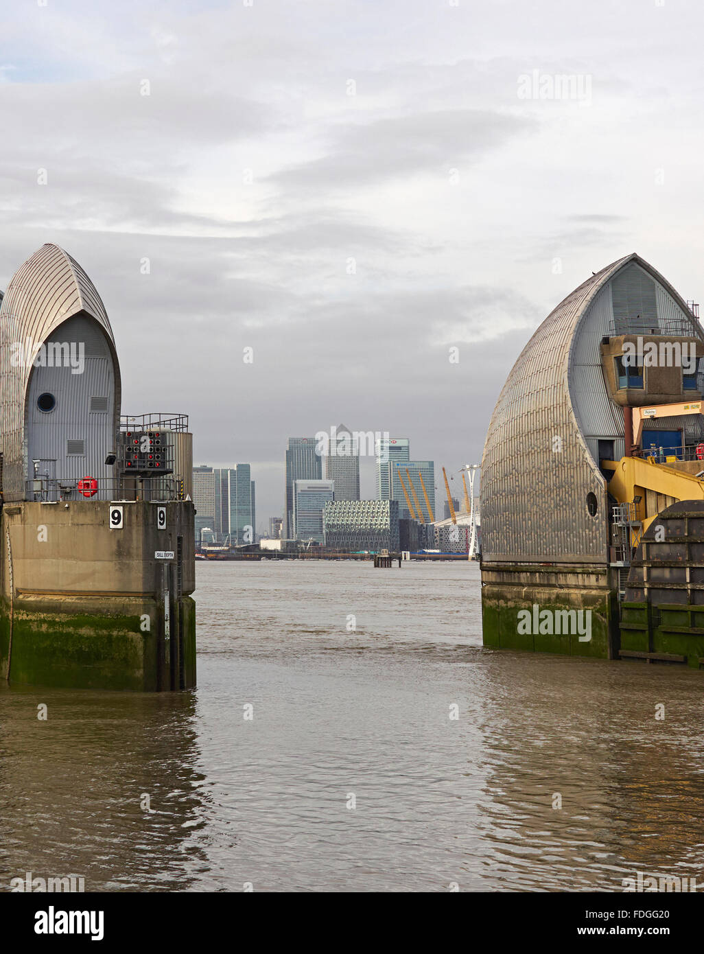 River Thames Barrier London Hochwasserschutz Woolwich mit Canary wharf Bankenviertel Stockfoto