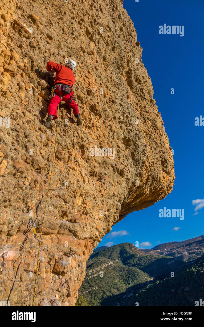 Ältere Bergsteiger auf steilen Felswand mit blauem Himmel rot Stockfoto