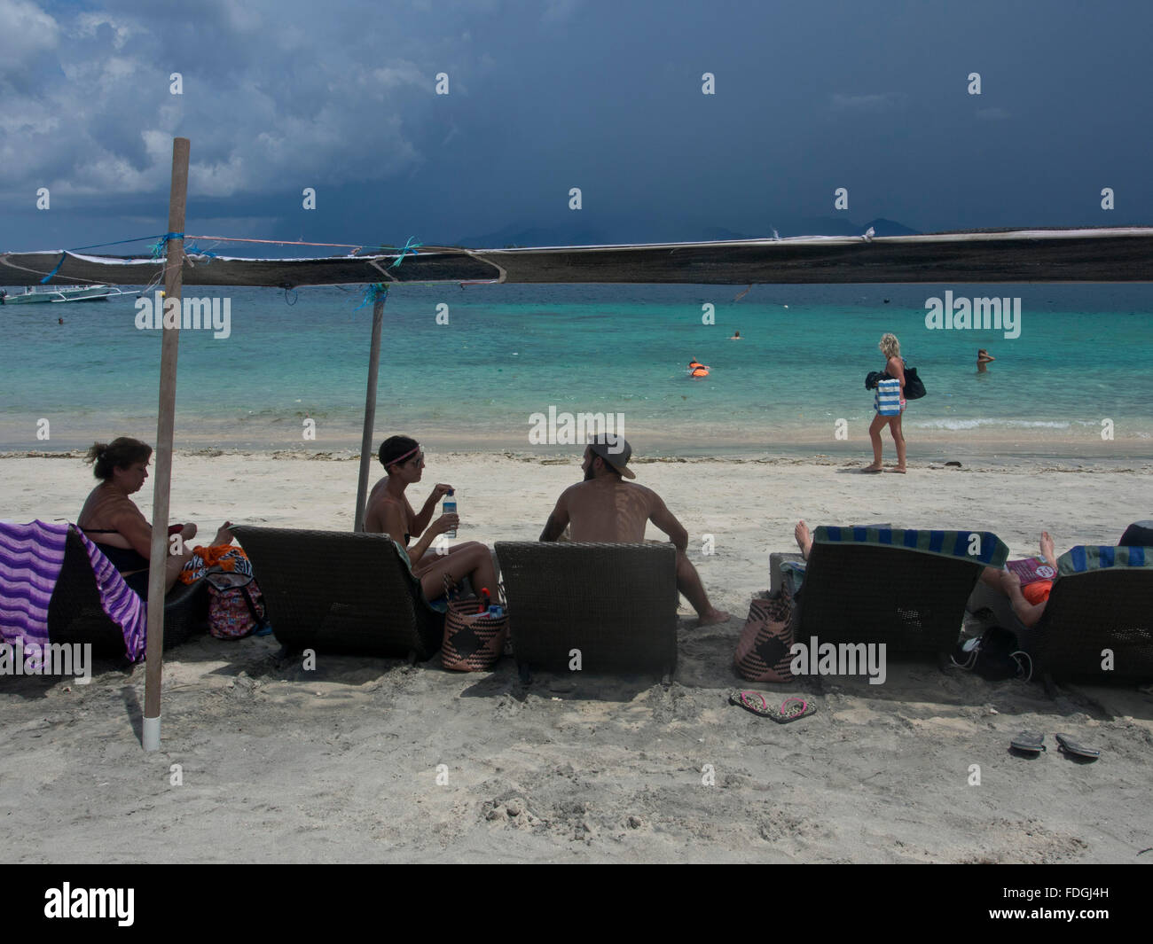 Touristen und traditionelle Boote am Strand von Gili Air Insel Lombok, Indonesien Stockfoto