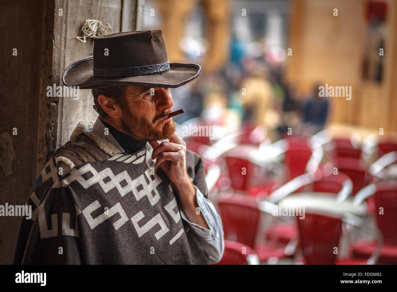 Alter Mann gekleidet für Karneval mit braunen alten Cowboy-Hut raucht eine Zigarre in Venedig Italien Stockfoto