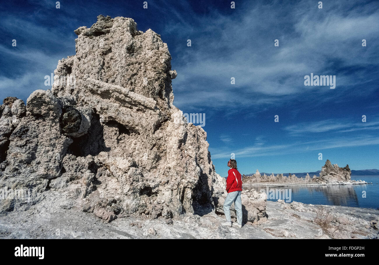 Eine riesige Formation von Tuffstein wird von einem weiblichen Besucher zum Mono Lake Tufa State Naturschutzgebiet in Mono County, Kalifornien, USA aus nächster Nähe angesehen. So genannte "Tuffstein Türme werden erstellt, wenn Süßwasserquellen mit dem alkalischen Seewasser zu Form Knöpfe interagieren und Türme von Calcium Carbonat dieser Aufstieg oberhalb des alten Sees. Mono Lake ist über 1 Million Jahre alt und hat keinen Ausgang. Stockfoto