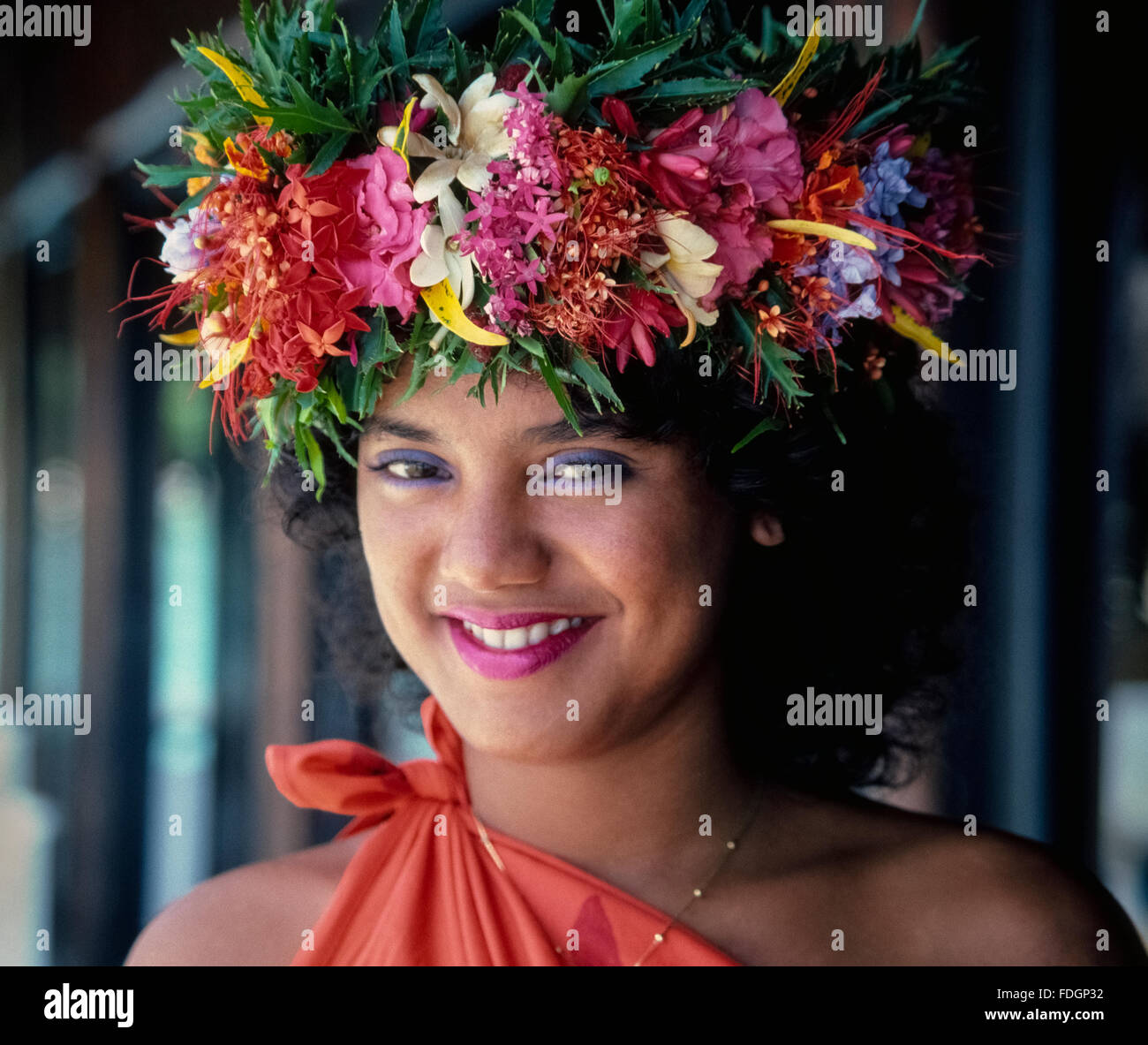 Eine traditionelle tahitische Blumenkrone trägt zur Schönheit dieses lächelnden Mädchens auf der Insel Moorea in Französisch-Polynesien im Südpazifik bei. Die Blumengirlande wird in der tahitischen Sprache als „hei“ bezeichnet und wird in der Regel von Bräuten und Bräutigam sowie von Tänzerinnen in polynesischen Shows für Besucher der Inseln getragen. Die bunten Kopfschmuck werden mit einer Vielzahl von frischen Blumen, vor allem der duftenden Tiare (Gardenia) und Jasmin. Stockfoto