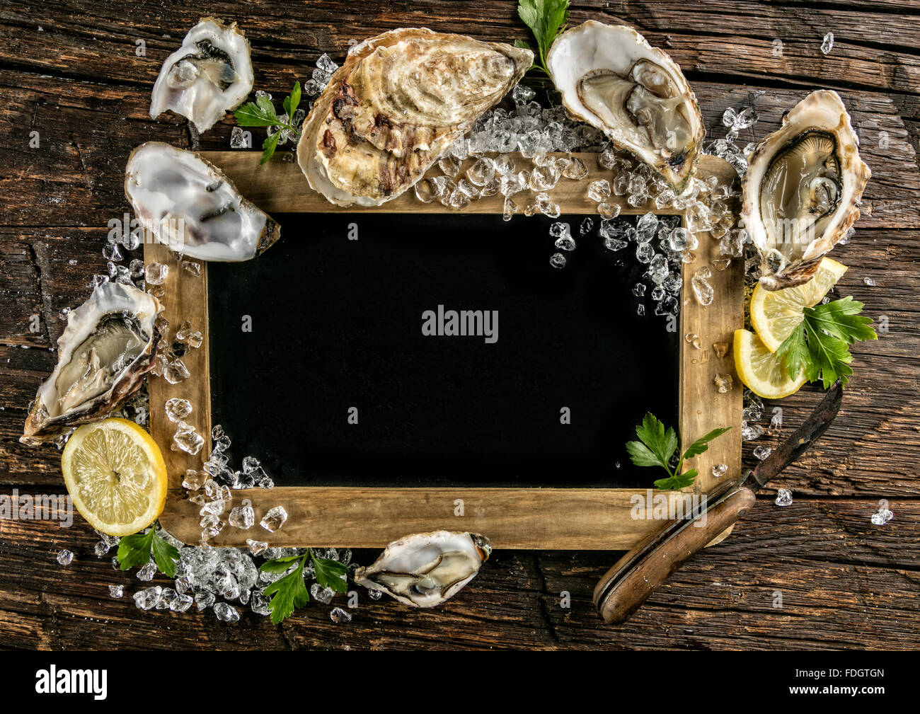 Austern auf Holz mit Tafel serviert Stockfoto