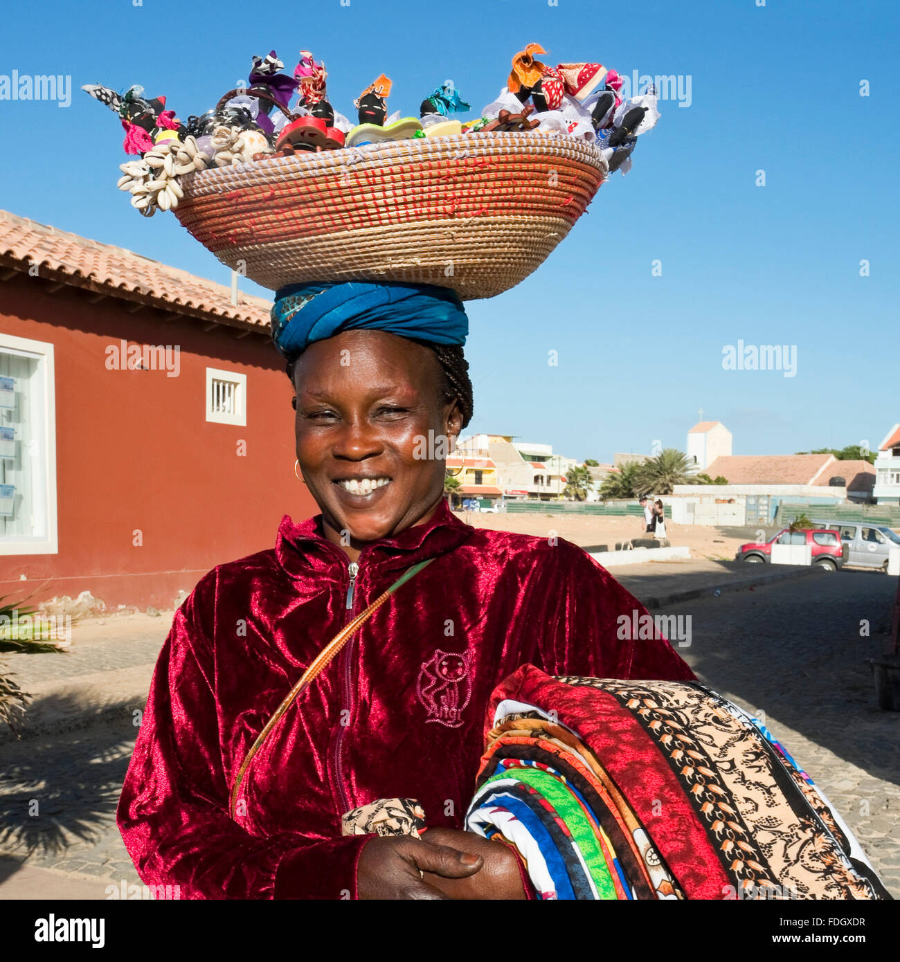 Quadratische Porträt einer lokalen kapverdischen Frau mit Souvenirs aus einem Korb auf dem Kopf in Kap Verde Inseln ausgeglichen. Stockfoto