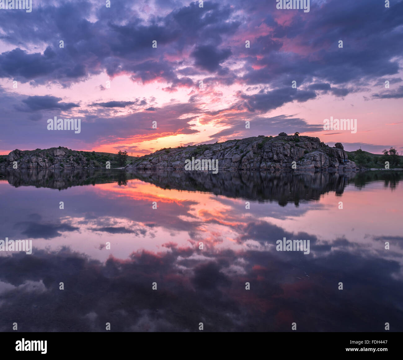 Schöne Landschaft. Farbenprächtigen Sonnenuntergang am See mit Wolken spiegeln sich in Wasser. Stockfoto