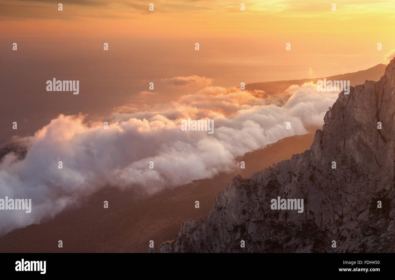 Wunderschöne Landschaft auf Hügeln mit tiefhängenden Wolken bei Sonnenuntergang. Natur-Hintergrund Stockfoto