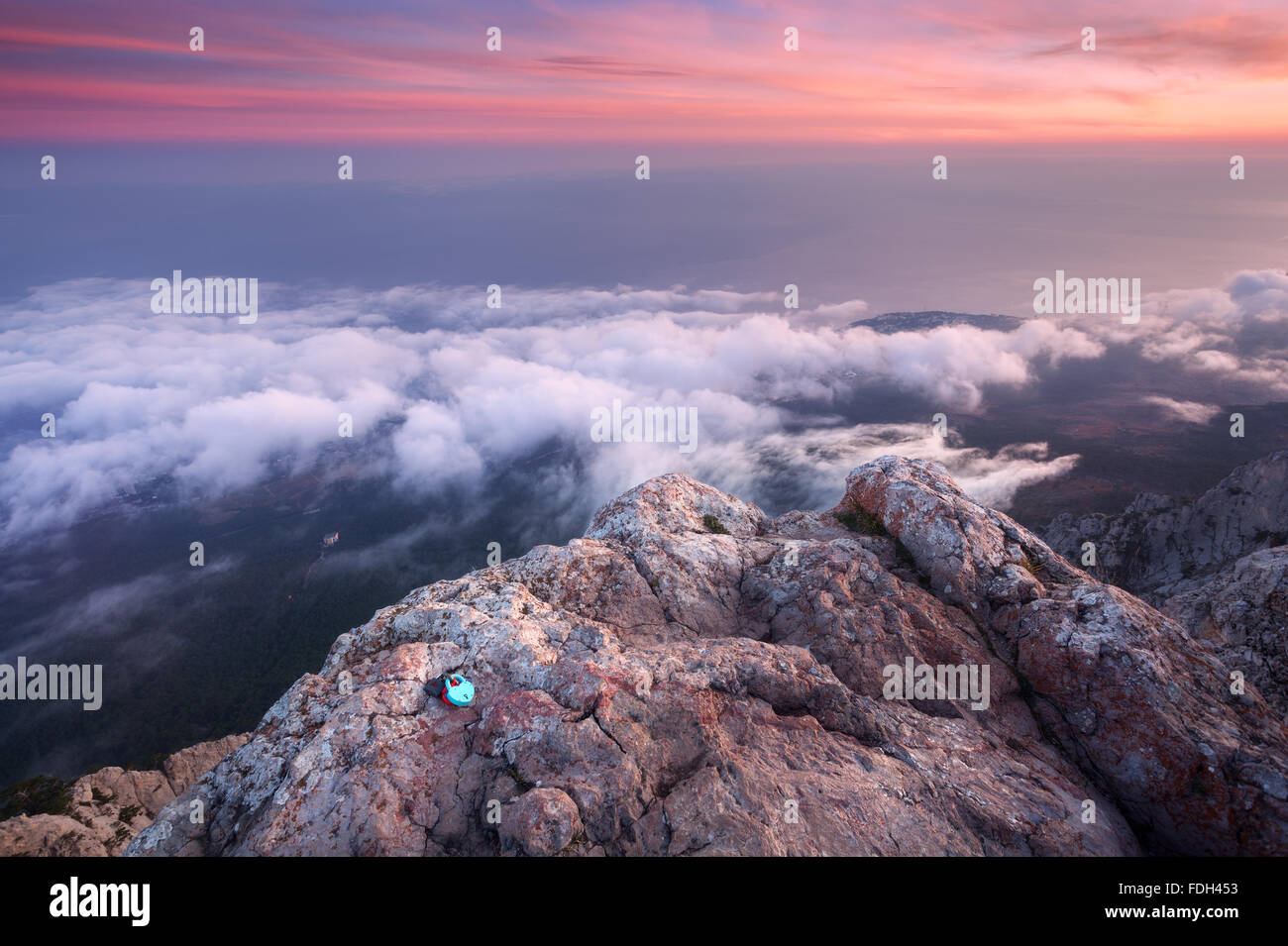 Wunderschöne Landschaft auf dem Gipfel der Berge mit Meer, farbenprächtigen Sonnenuntergang und tief hängenden Wolken. Natur-Hintergrund Stockfoto