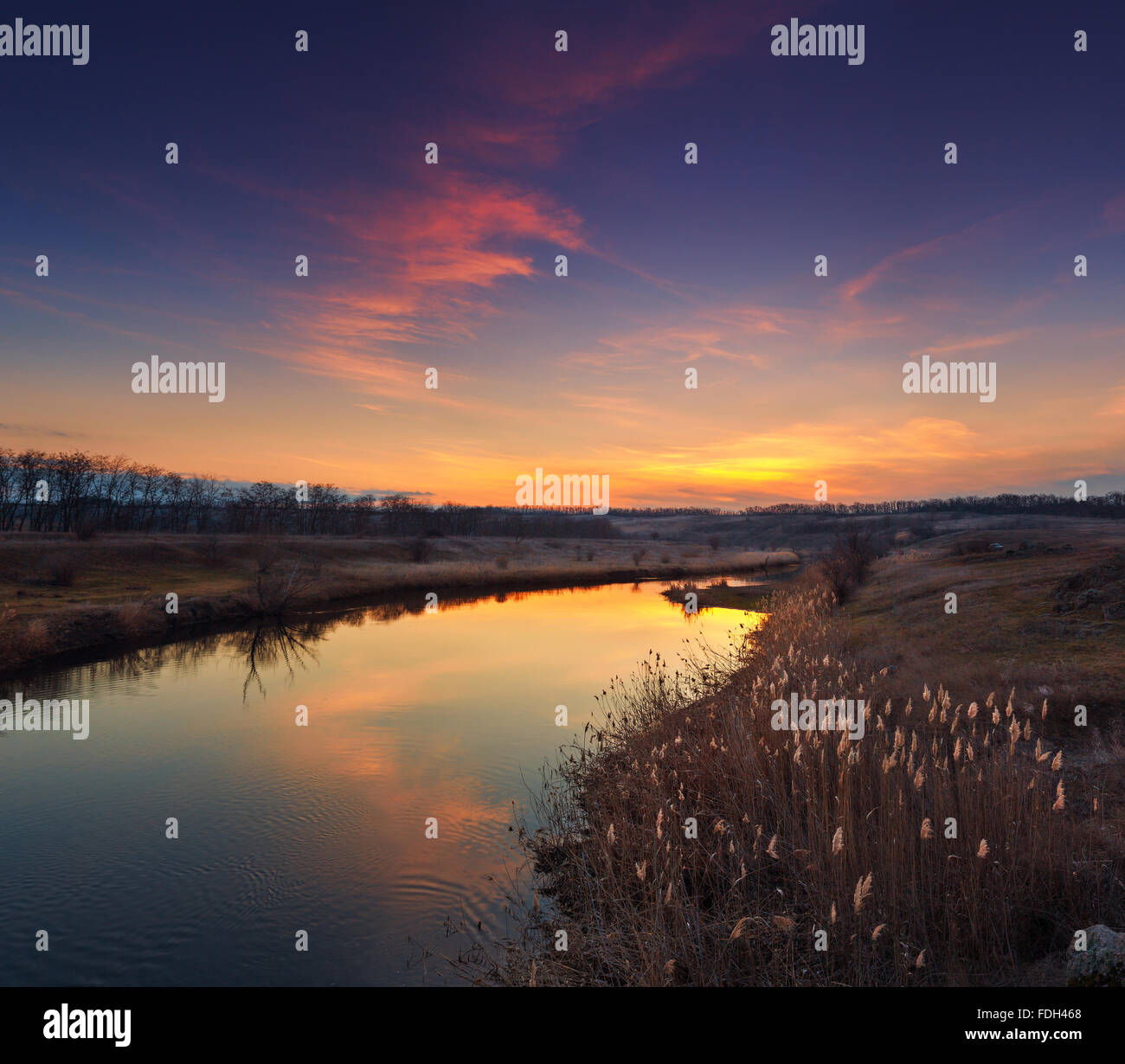 Bunter Herbst Sonnenuntergang mit Wolken spiegeln sich in den Fluss. Stockfoto