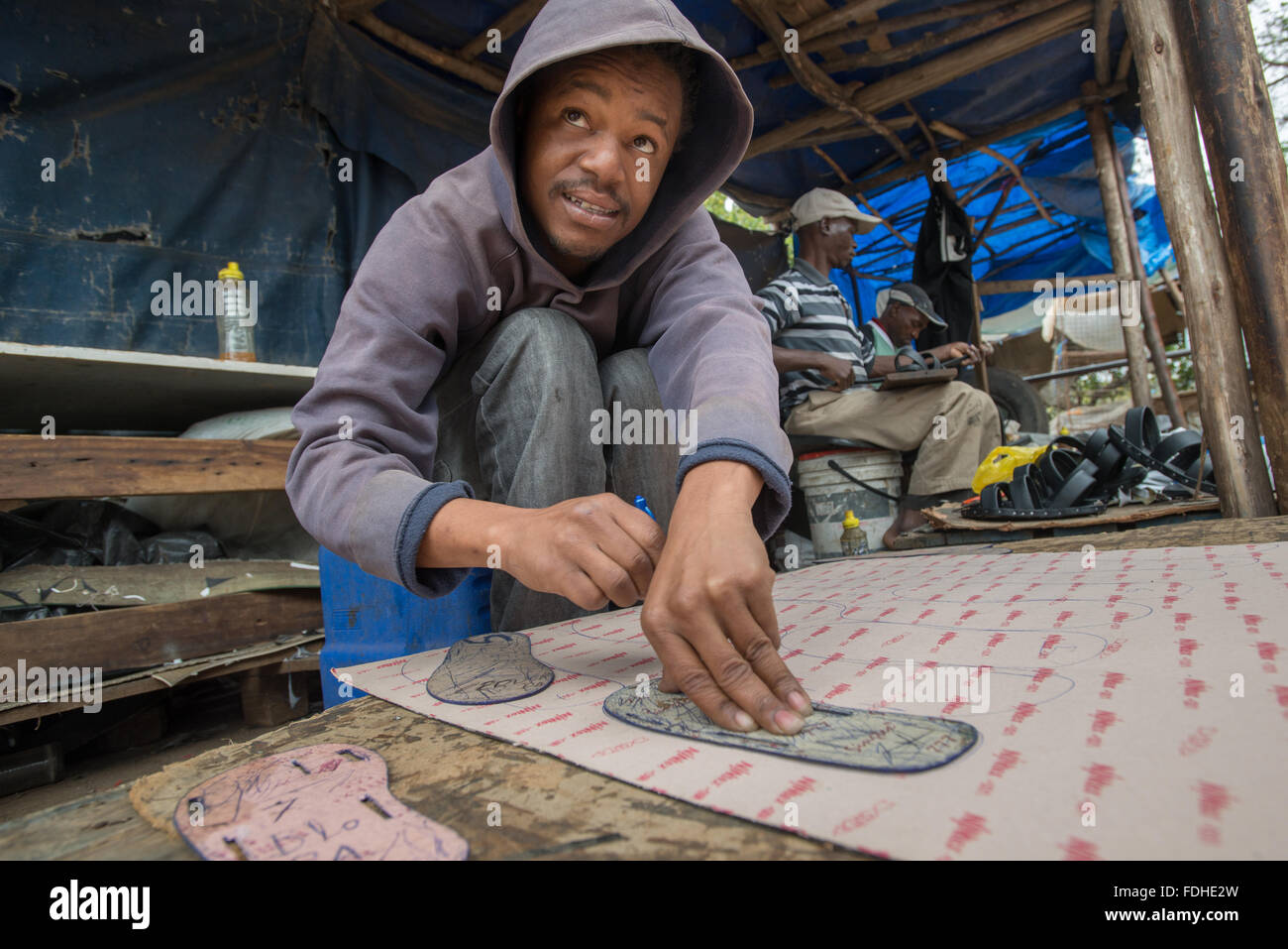 Junge afrikanische Männer, die Herstellung von Schuhen in Manzini Großhandel produzieren und Handwerksmarkt in Swasiland, Afrika Stockfoto