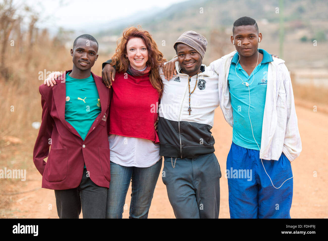 Gruppenfoto eines weiblichen Touristen mit 3 lokalen jungen Männern in der Hhohho Region von Swasiland, Afrika. Stockfoto