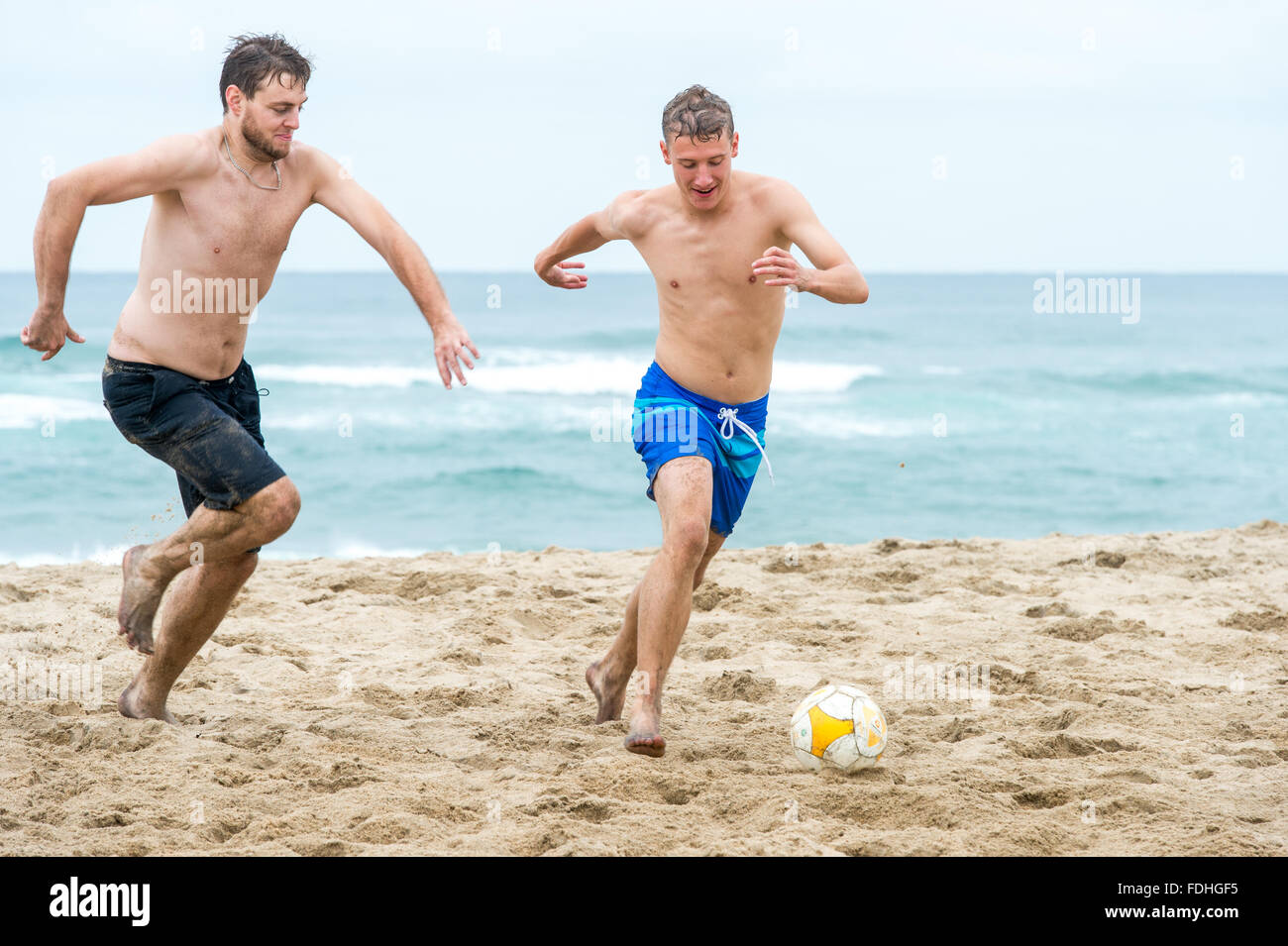 Junge Männer, die Fußball spielen, am Strand von St. Lucia, Kwazulu-Natal, Südafrika - iSimangaliso Wetland Park Stockfoto