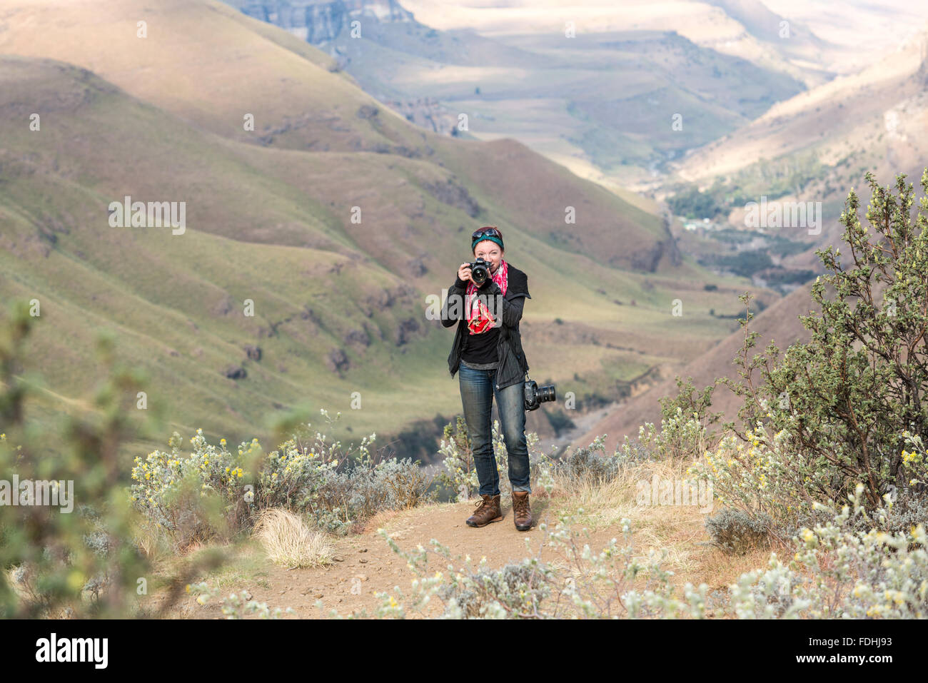 Eine Frau Fotografen stehen mit ihrer Kamera in den Bergen in Sani Pass, zwischen Südafrika und Lesotho. Stockfoto