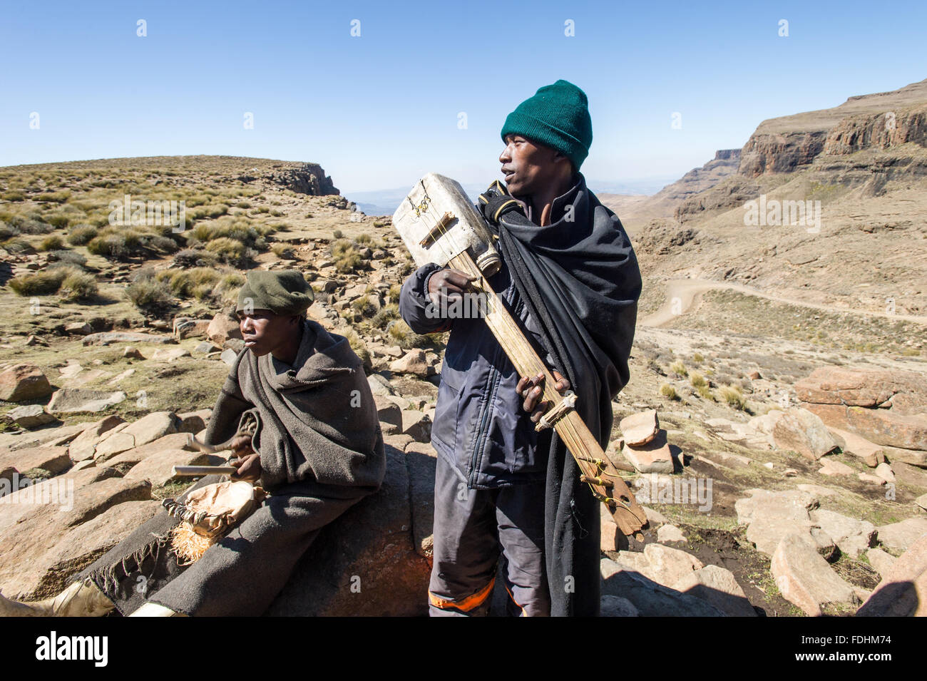 Zwei lokale Männer spielen handgefertigte Instrumente in den riesigen Bergen von Lesotho, Afrika Stockfoto