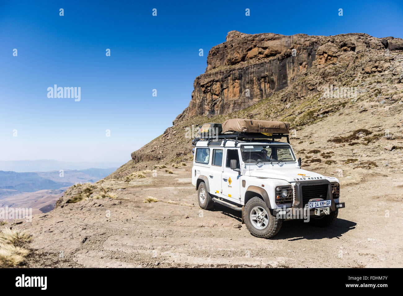 Land Rover Defender geparkt an einem Berghang in Lesotho, Afrika Stockfoto