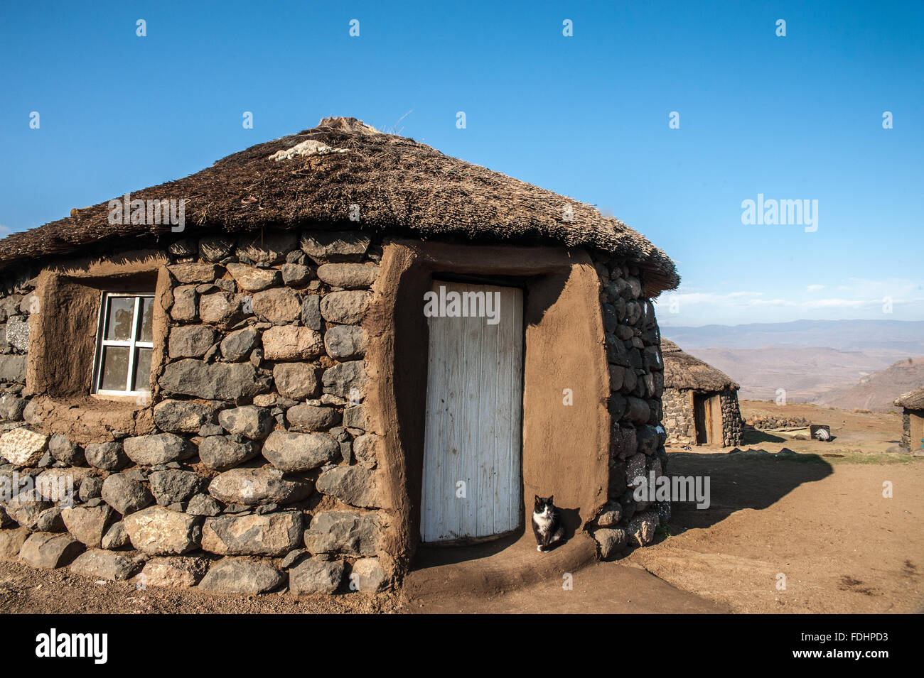 Dorf-Hütte mit einer Katze auf der Veranda in Lesotho, Afrika Stockfoto