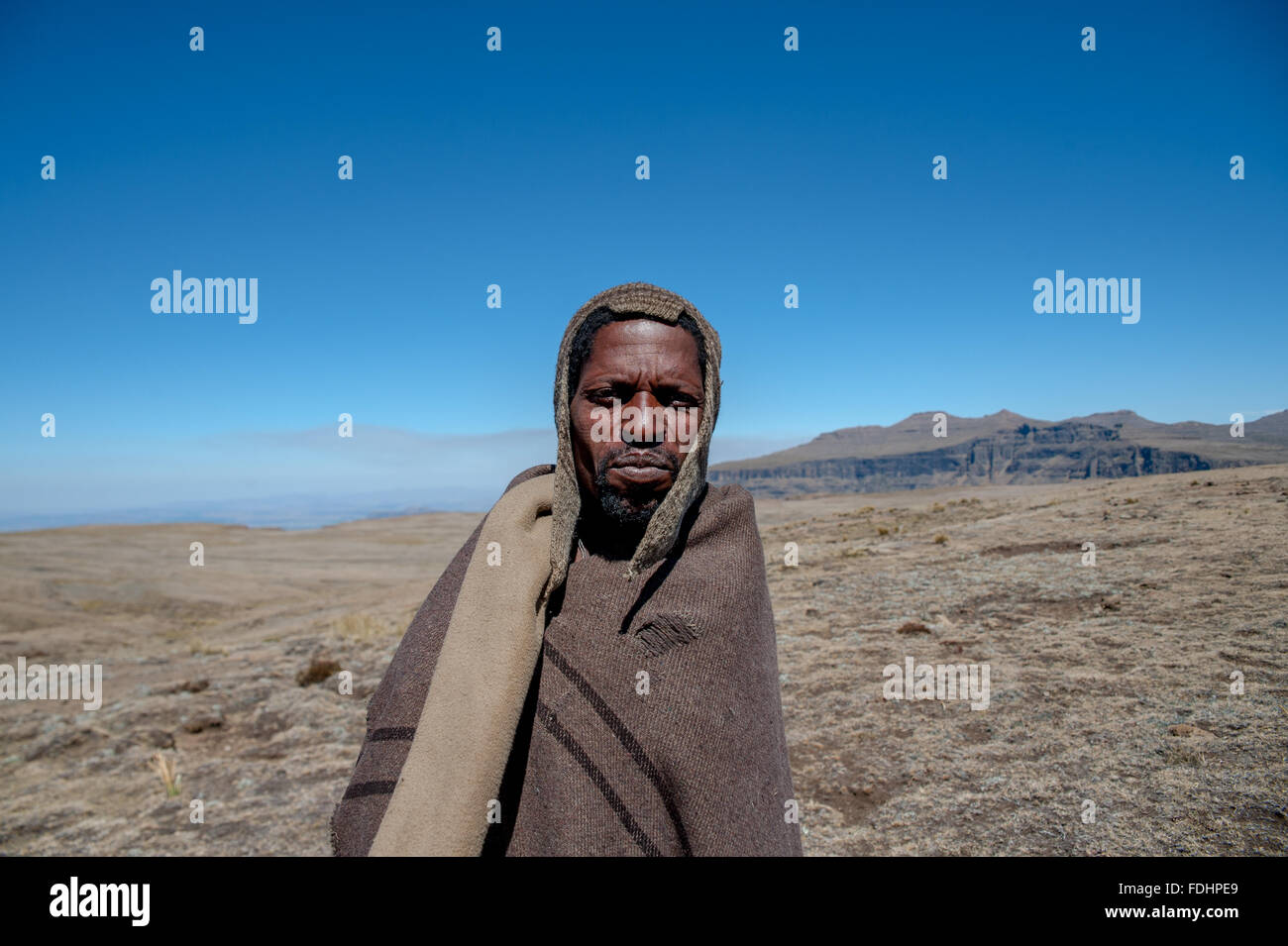 Hirte stehend in einer weiten Ebene, eingewickelt in Decken in Lesotho, Afrika Stockfoto