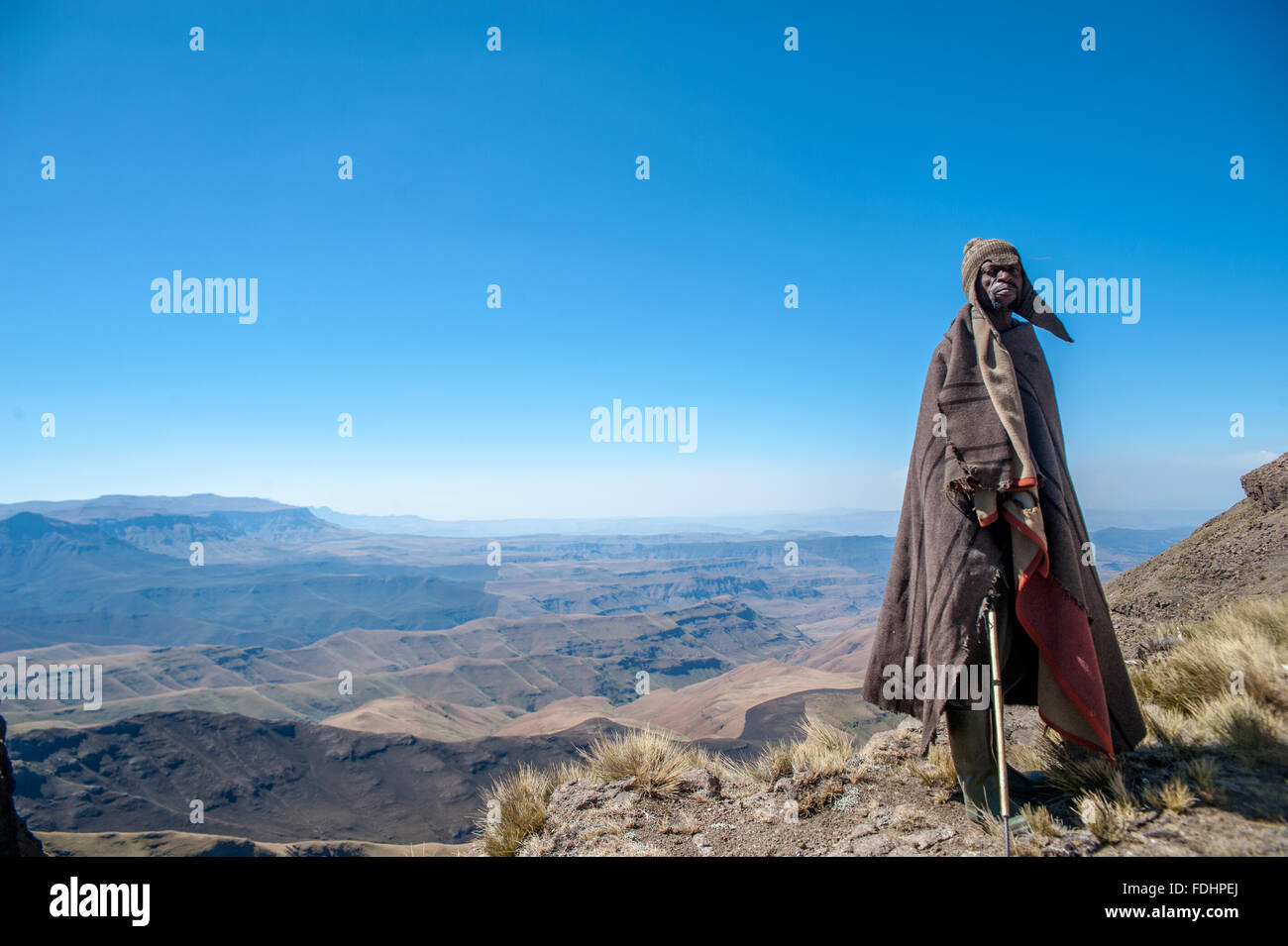 Hirte stehend vor einer Bergkette eingewickelt in Decken in Lesotho, Afrika Stockfoto