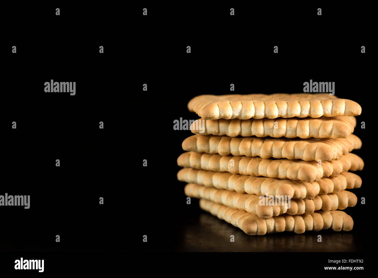 Stapel von knusprige Cracker vor schwarzem Hintergrund Stockfoto