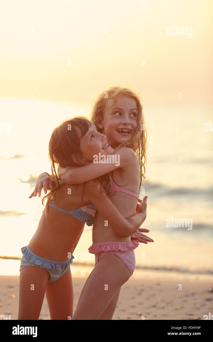 zwei glückliche Mädchen in Baden passt am Meer miteinander kuscheln Stockfoto