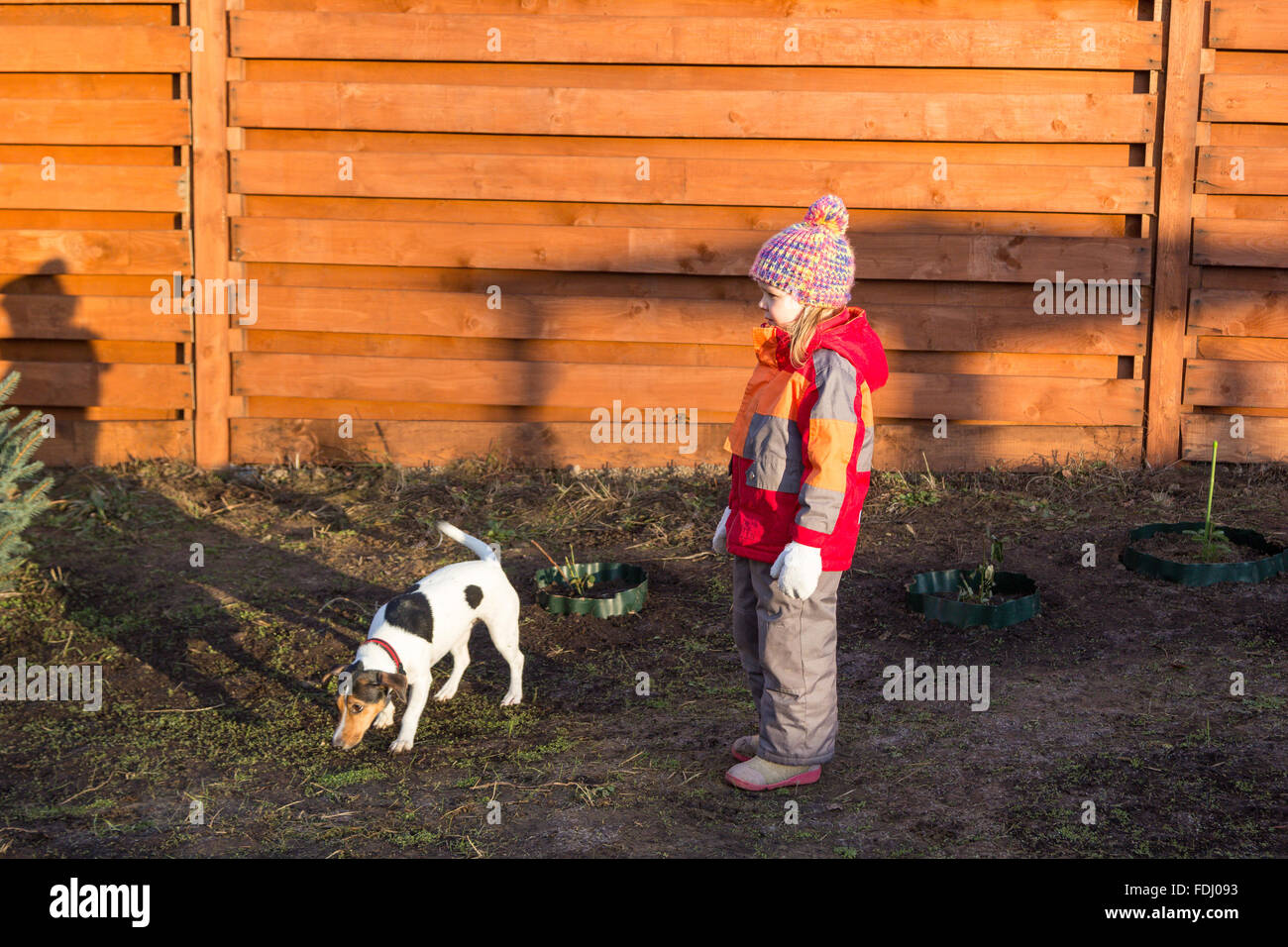 kleines Mädchen mit dem Hund in den Garten gehen Stockfoto